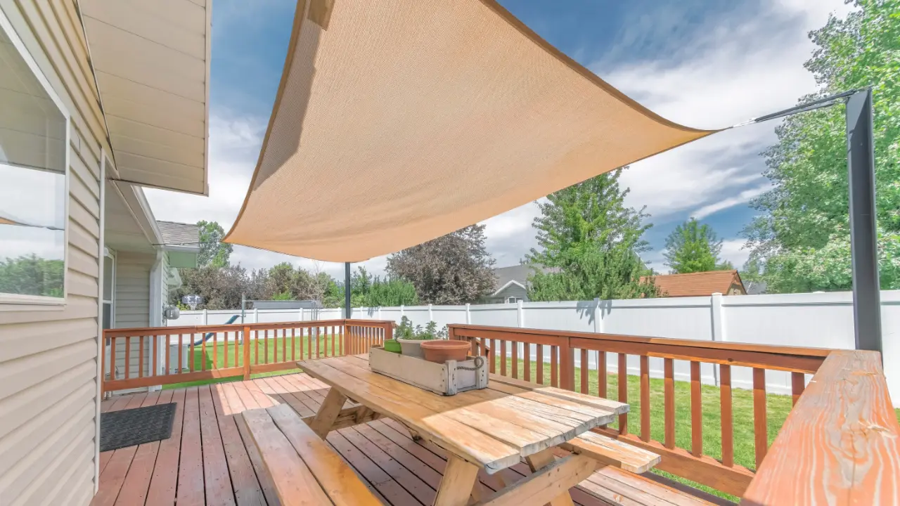 A deck with a picnic table and a shaded area.