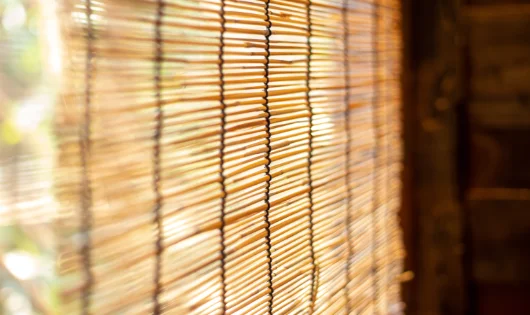 A close-up of a window with bamboo matchstick blinds.