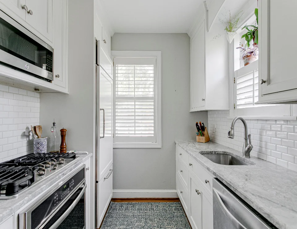 A small kitchen with white shutters.