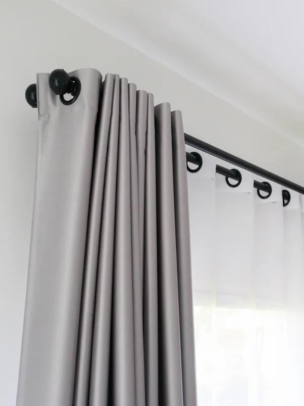 A gray curtain with grommets for hanging.