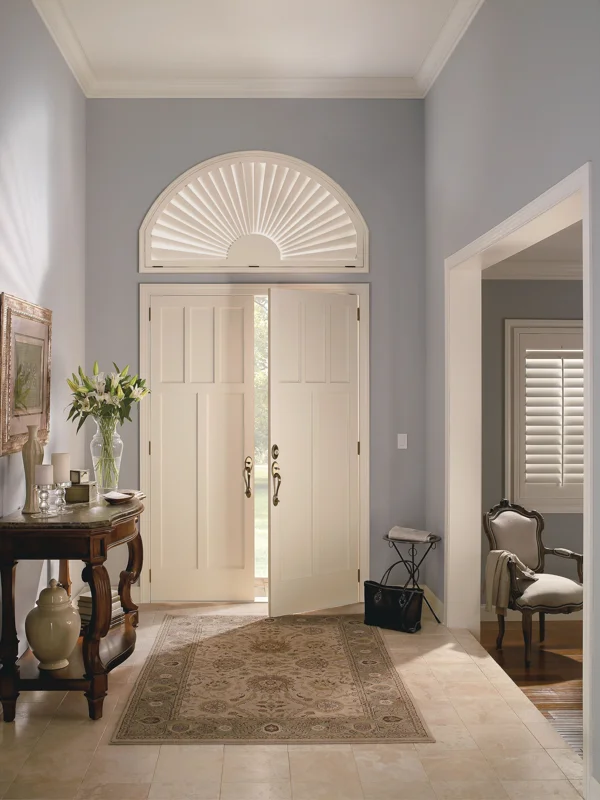 An entryway with a white door and a rug.