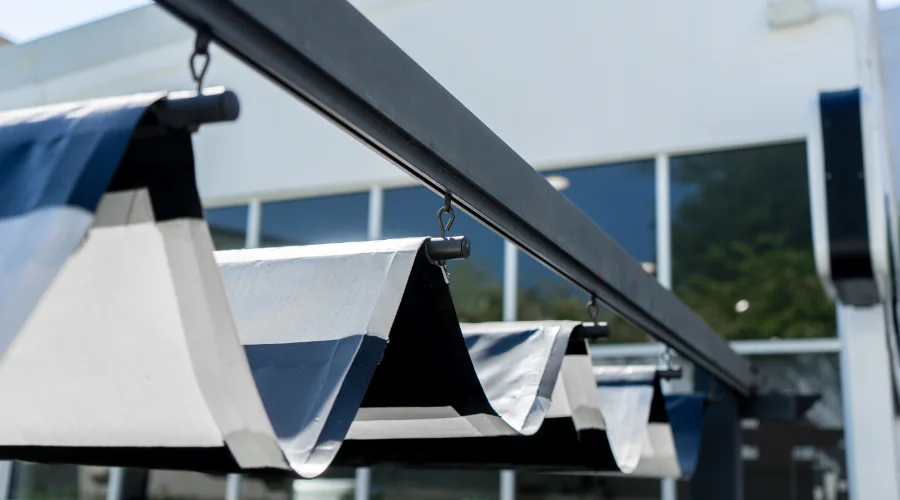 Black and white slide-wire cable awnings outside a commercial building.
