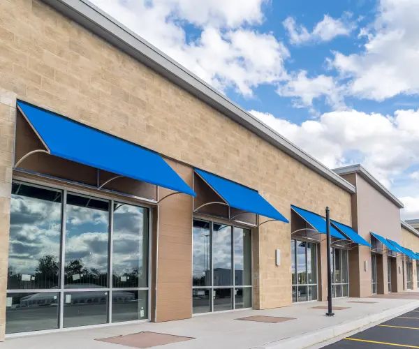 A commercial building with blue awnings.