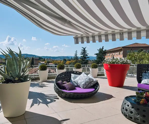 A balcony with a striped awning.