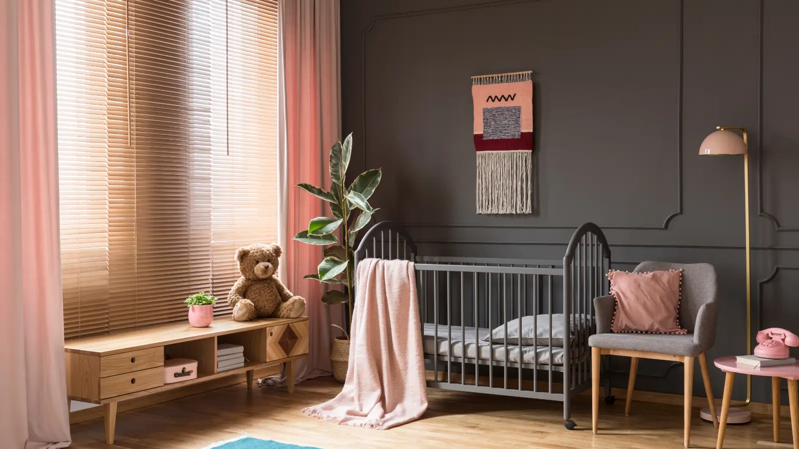 A child's room with a crib and a teddy bear.