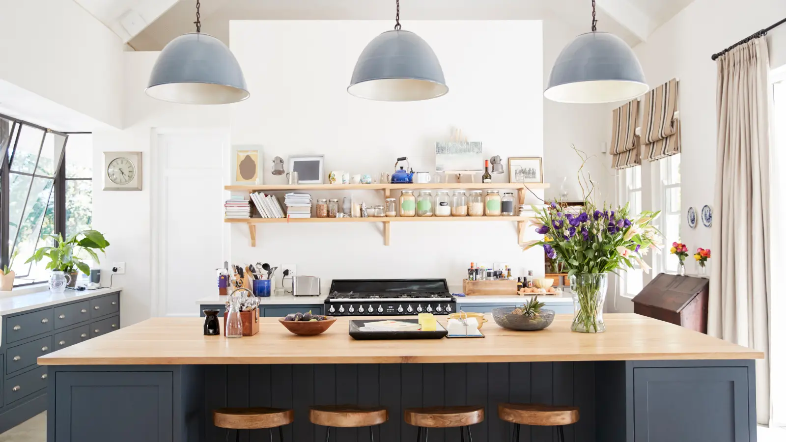 A kitchen with blue cabinets and wooden stools.