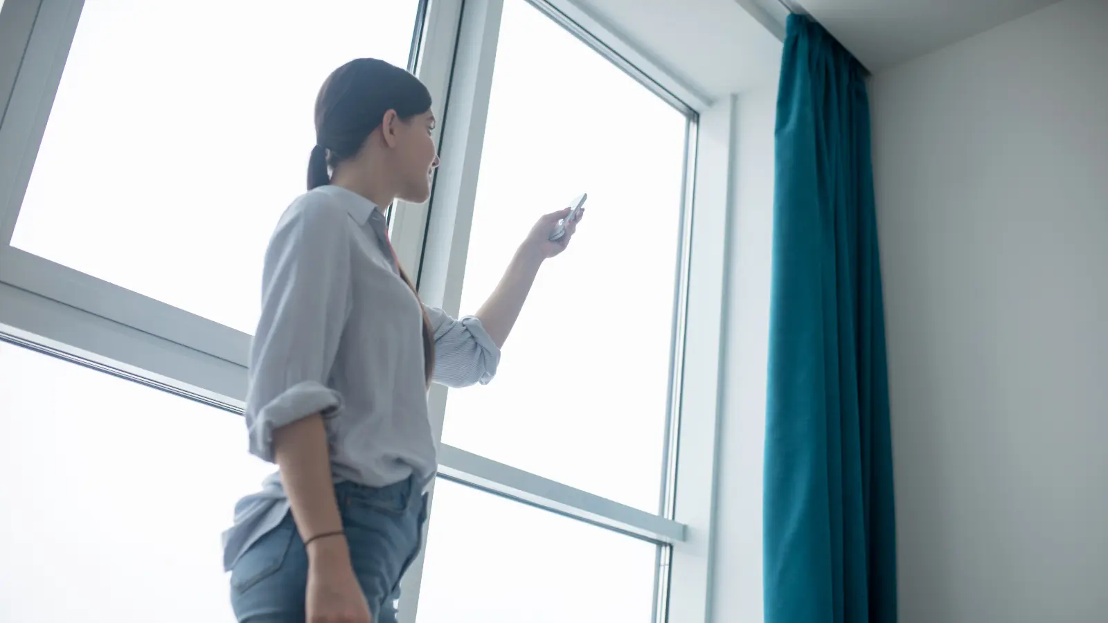 A woman standing in front of a window.