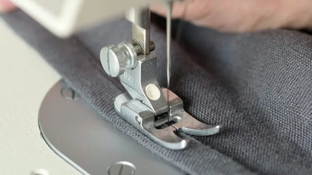 A person using a sewing machine to sew fabric.