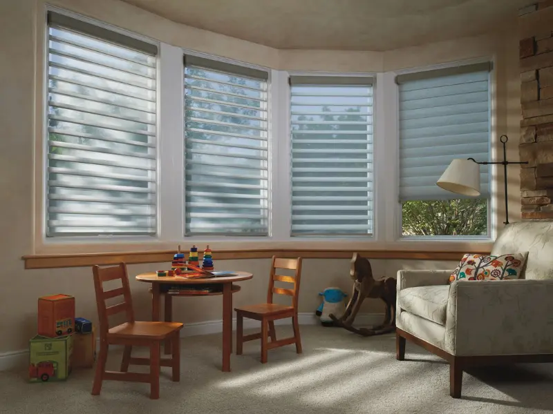 A cozy corner with wide-vaned silhouette shades covering the windows